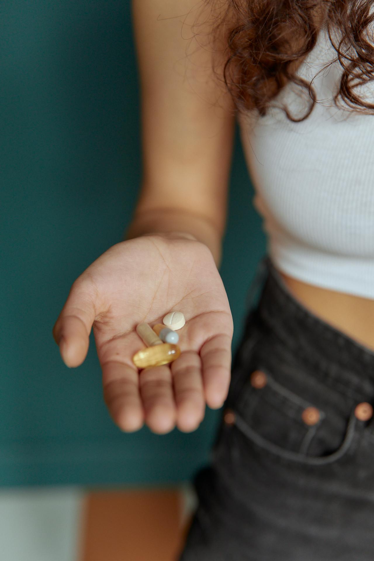 Daily supplement routine in a woman's hand, symbolizing consistency and daily hormonal support.